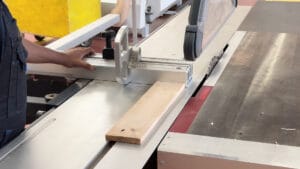 une élève qui coupe du bois avec une machine